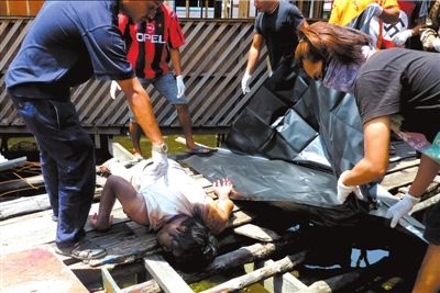 3月4日,在马来西亚仙本那,马警方在处置一具苏禄武装人员的尸体。图/东方IC