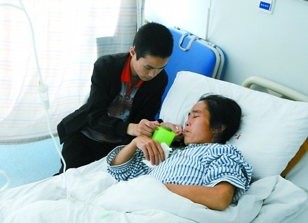 大坪医院,马开军正在照顾躺在病床上的母亲。 记者 张路桥 实习生 陈超摄