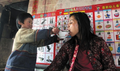 小孙悦为卧床的母亲喂饭。 小孙悦为卧床的母亲喂饭。