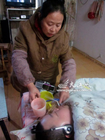 六旬夫妇照料瘫儿15年制“超级遥控器”缓其寂寞