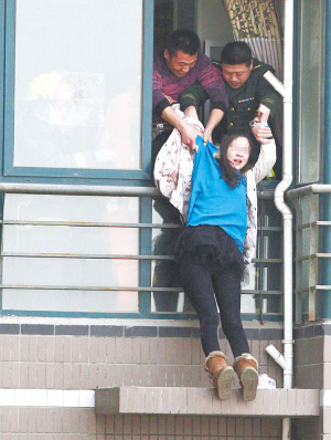 年轻女子在高楼窗外一小平台坐了1个多小时后,被消防官兵拉进屋内。 年轻女子在高楼窗外一小平台坐了1个多小时后,被消防官兵拉进屋内。